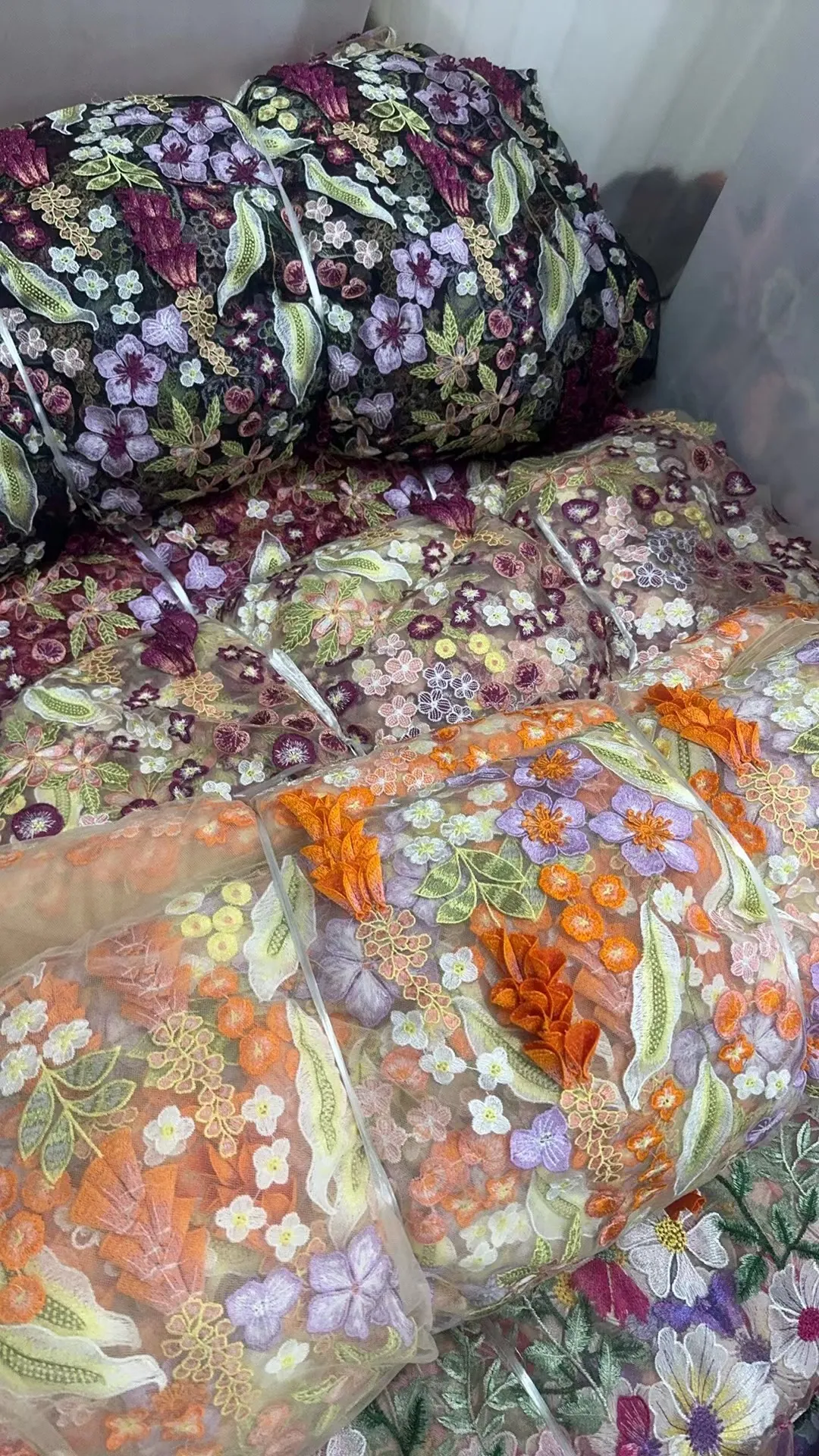 Rolos de tecidos bordados no armazém