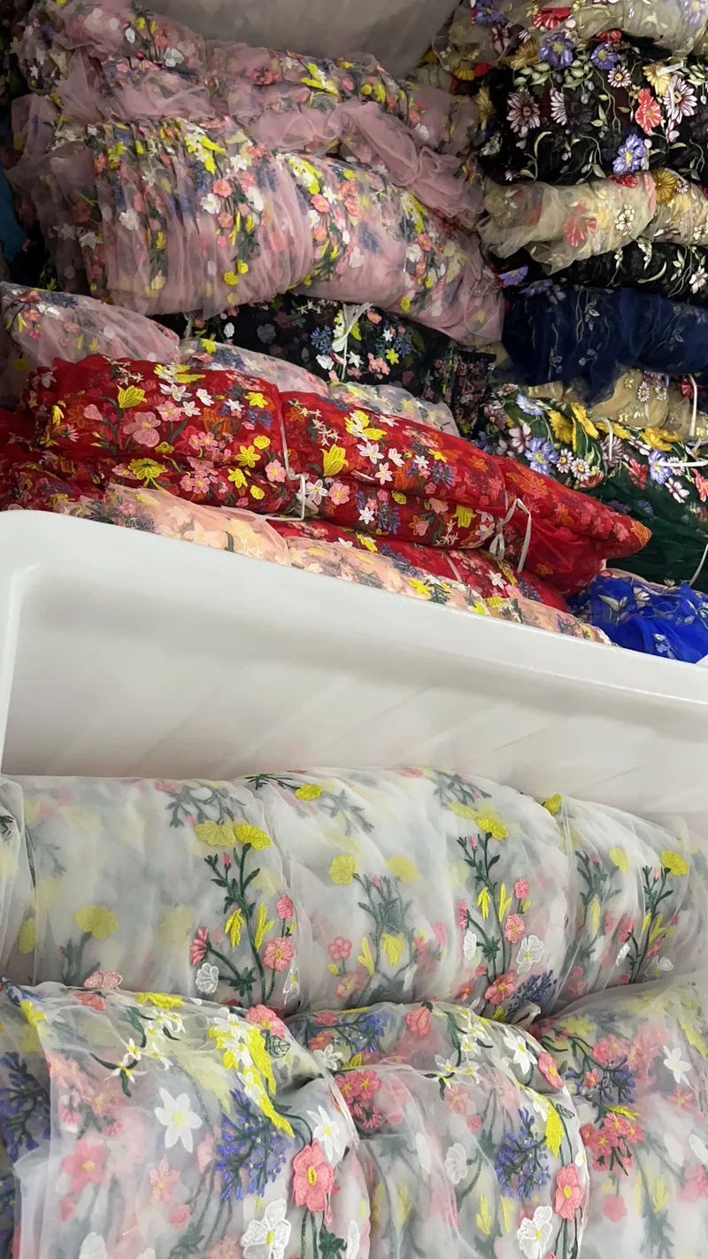 Rolos de tecidos bordados no armazém — 12