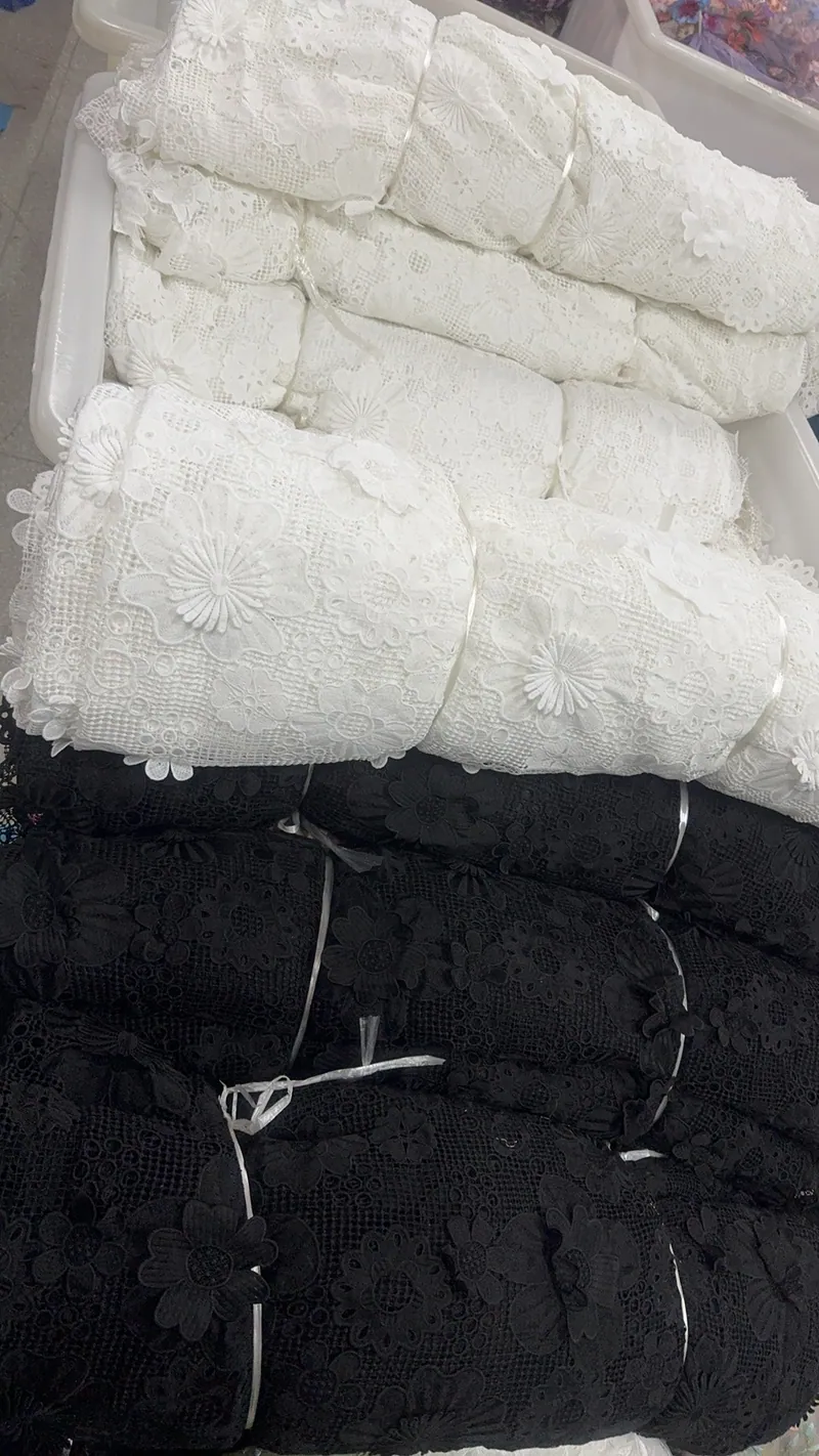 Rolos de tecidos bordados no armazém — 30