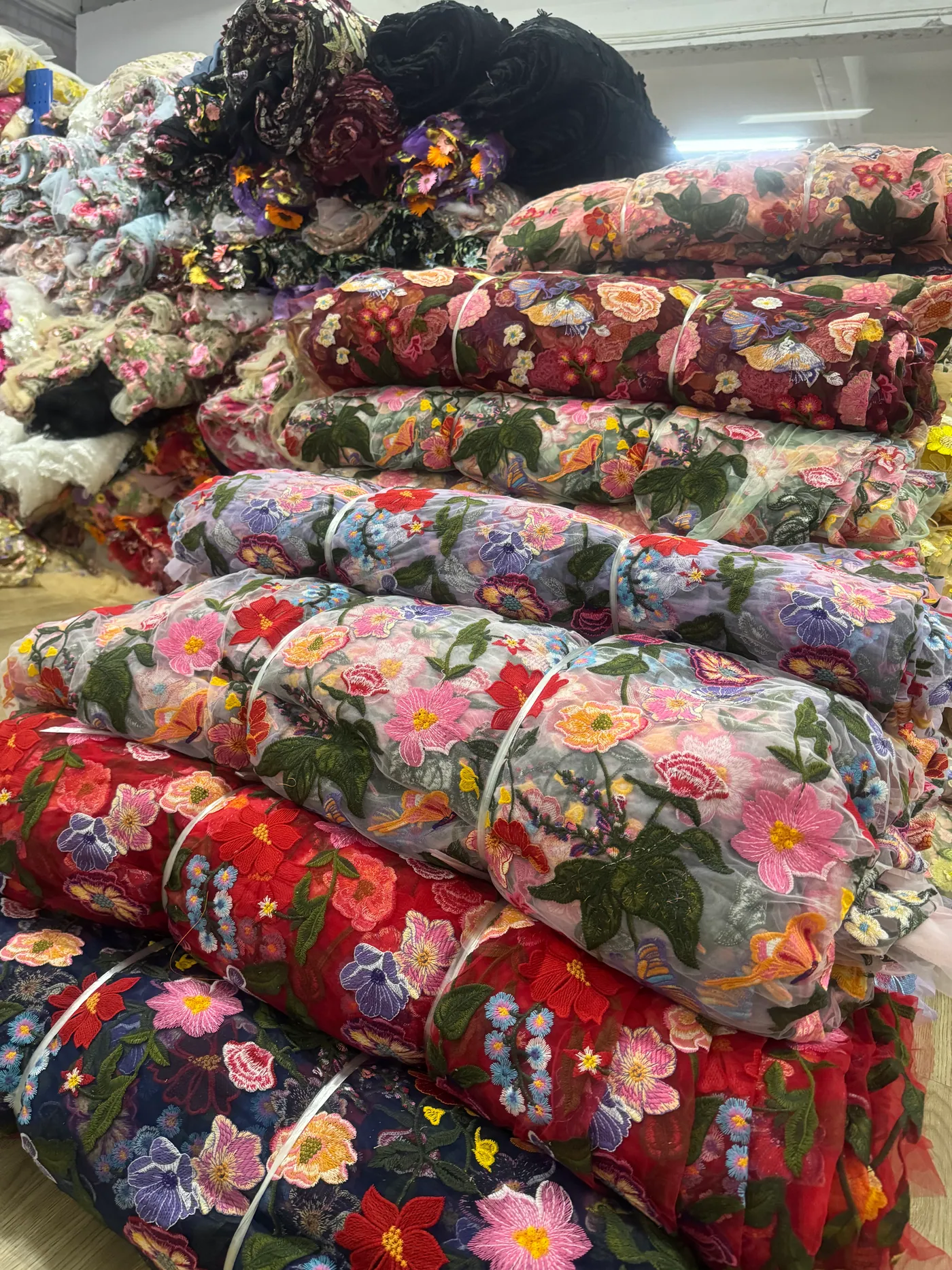Rolos de tecidos bordados no armazém
