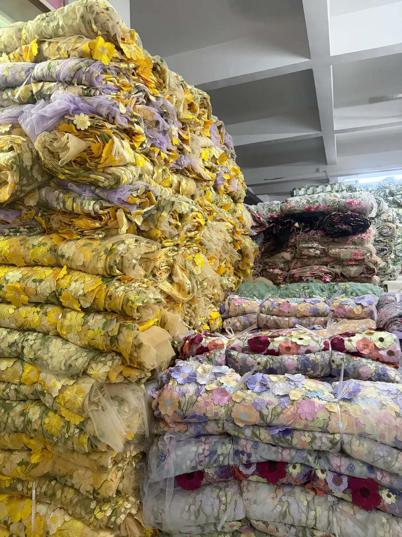 Rolos de tecidos bordados no armazém