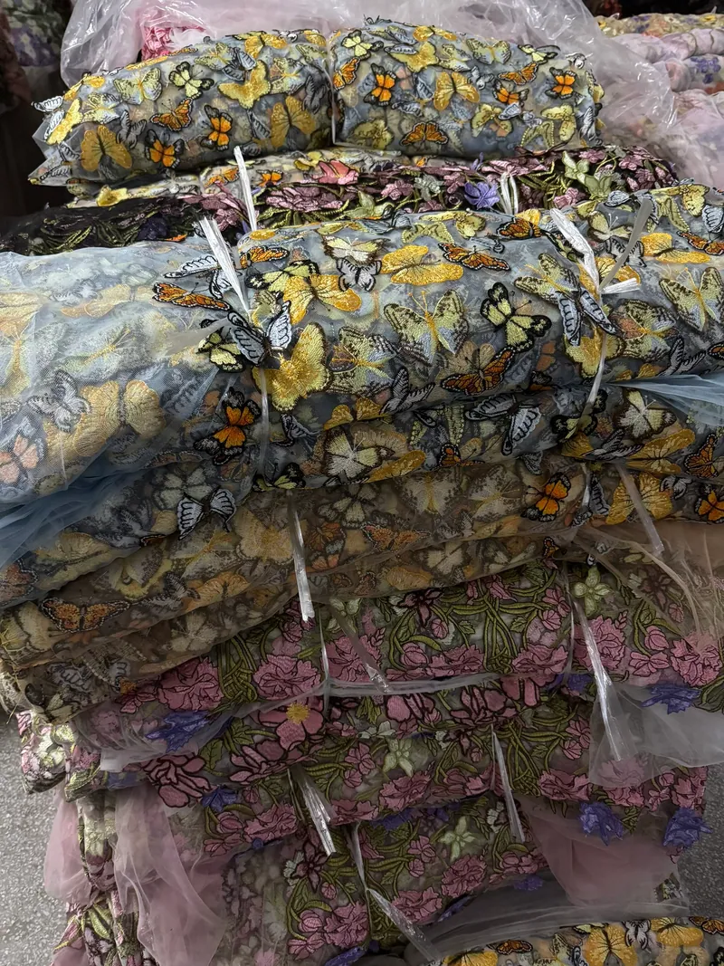 Rolos de tecidos bordados no armazém — 3
