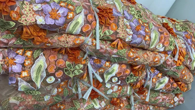 Rolos de tecidos bordados no armazém — 9